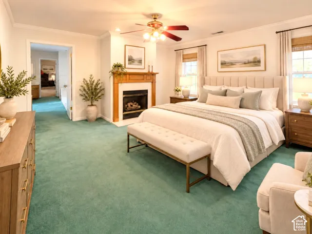 Fireplace with a wood mantle, multi-light ceiling fan, wall-to-wall carpeting, and crown molding