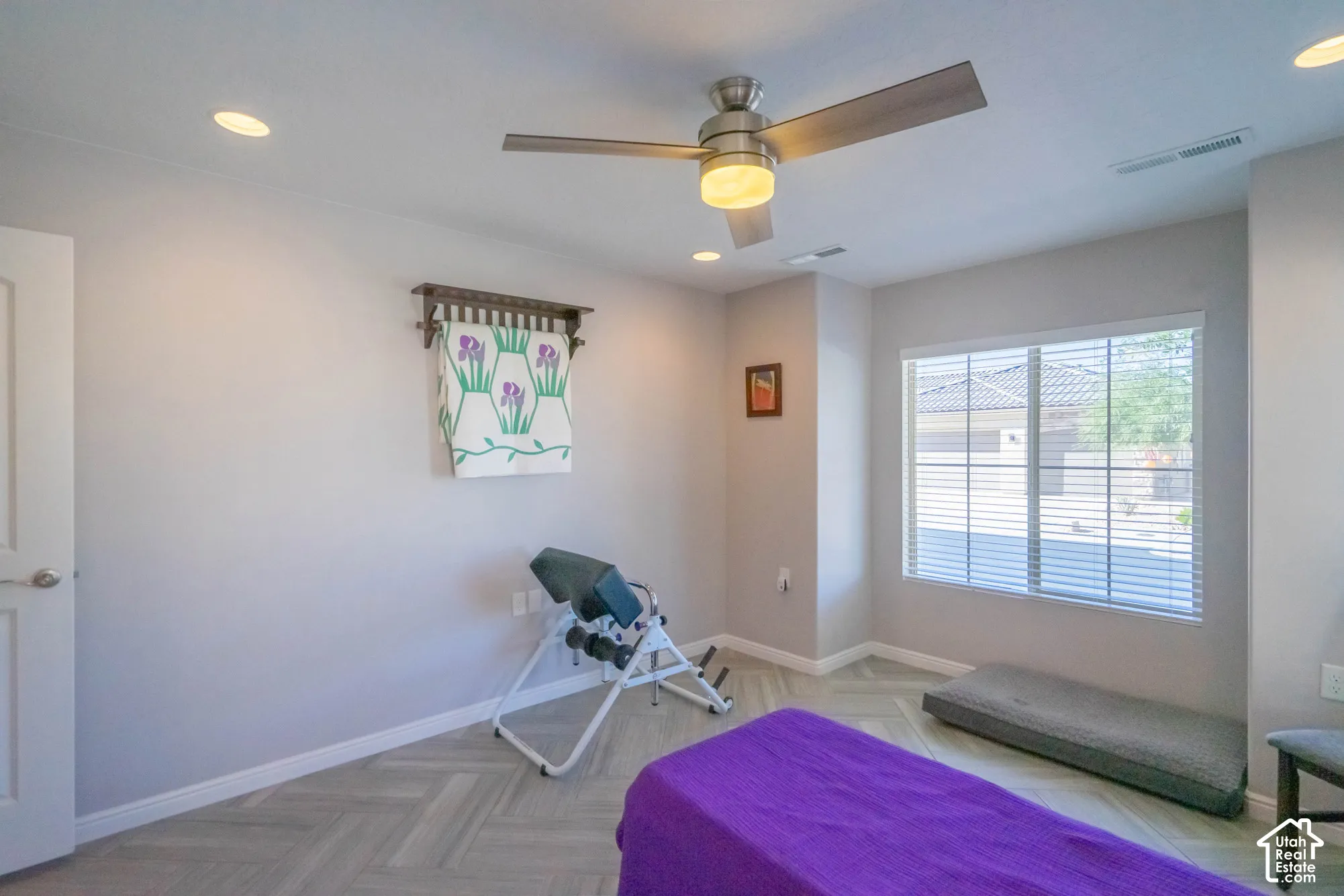 Neutral-toned interior featuring herringbone-patterned flooring, recessed lighting, and a modern brushed-metal ceiling fan with an integrated light fixture