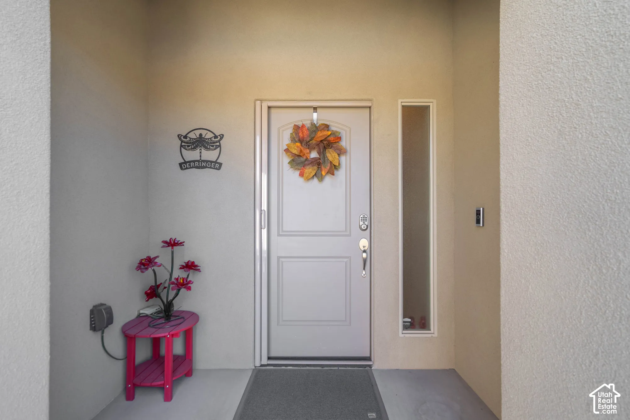 Entryway featuring a solid-panel door, vertical sidelight, and stucco wall finishes