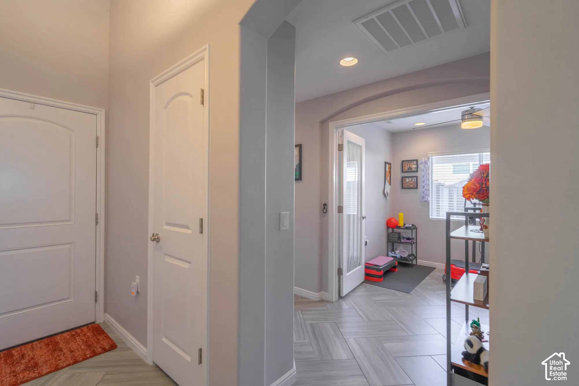 Herringbone-pattern tile flooring, arched wall openings, recessed lighting, and multi-panel interior doors