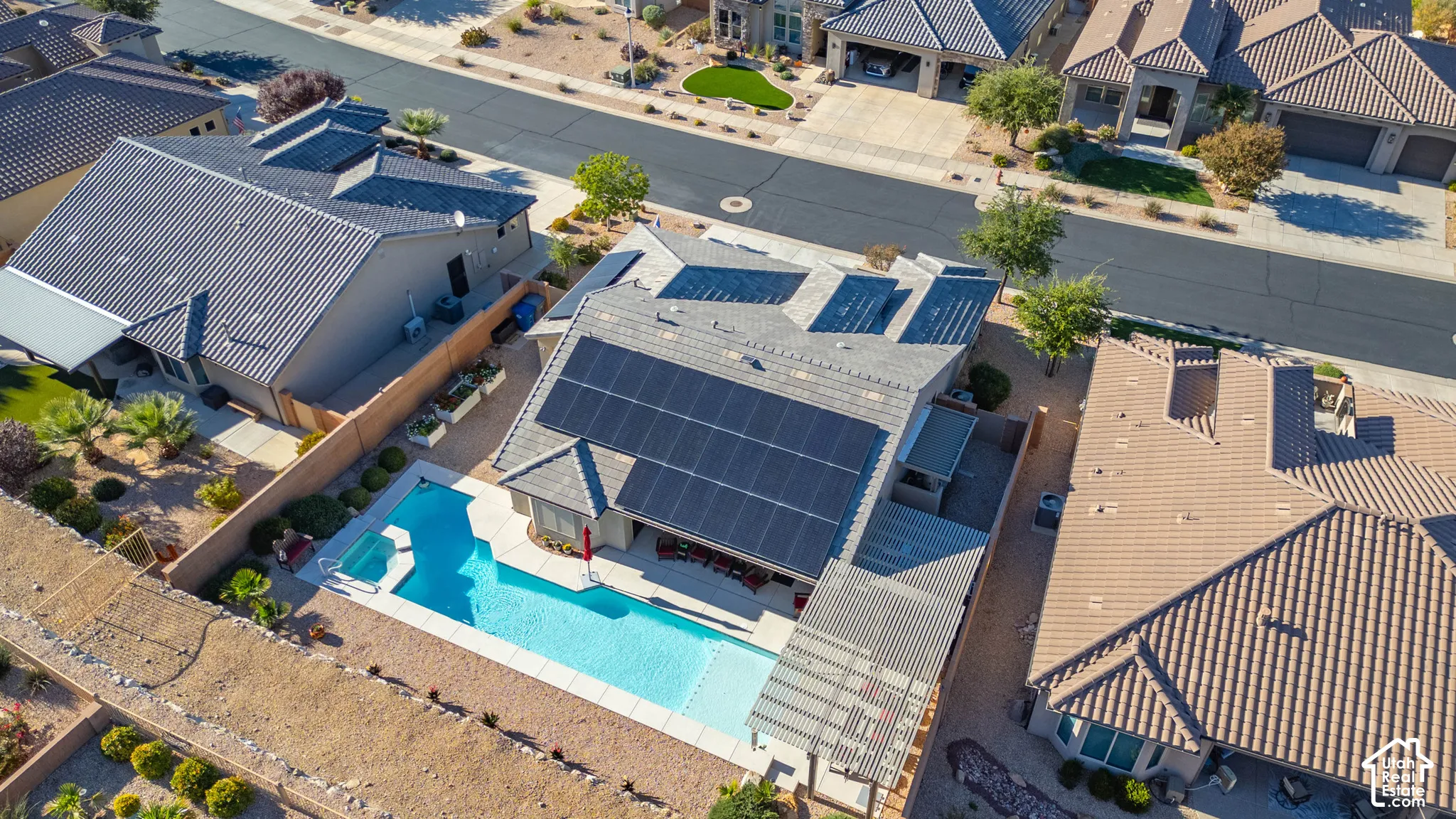 Exterior featuring a tiled roof, integrated solar panel system, swimming pool with spa, and a covered patio structure