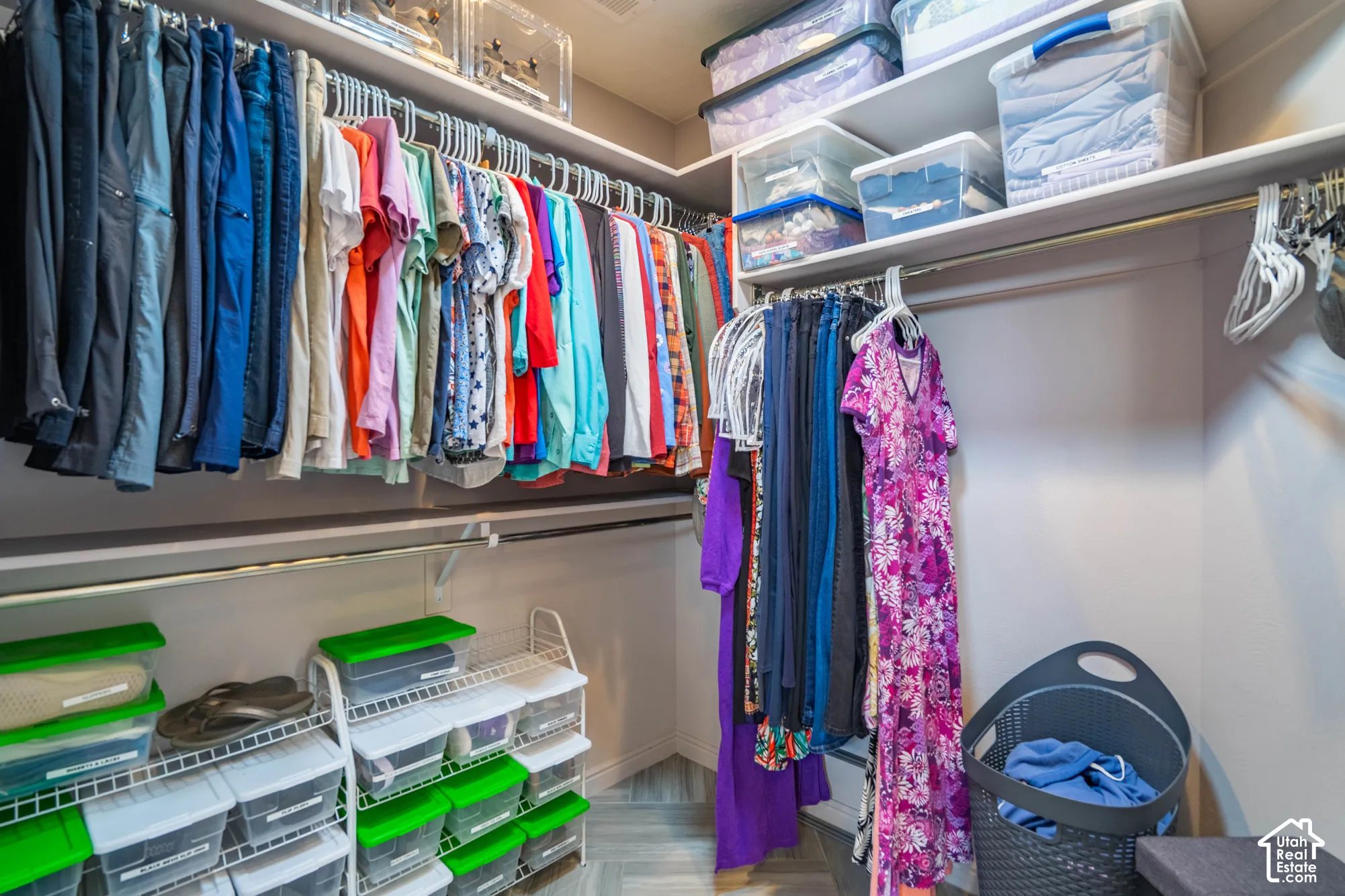 Walk-in closet featuring multi-level metal hanging rods and overhead shelving
