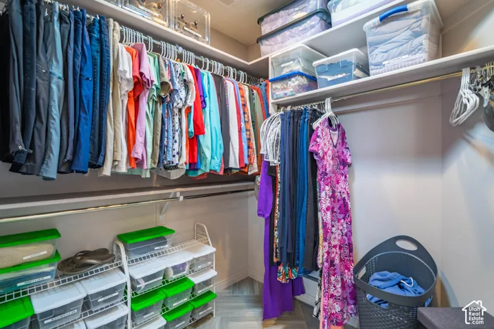 Walk-in closet featuring multi-level metal hanging rods and overhead shelving