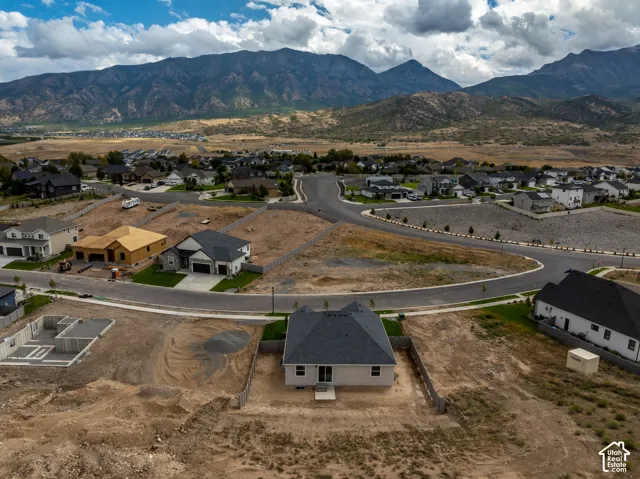 Aerial perspective of a residential lot featuring mountain scenery and paved street access