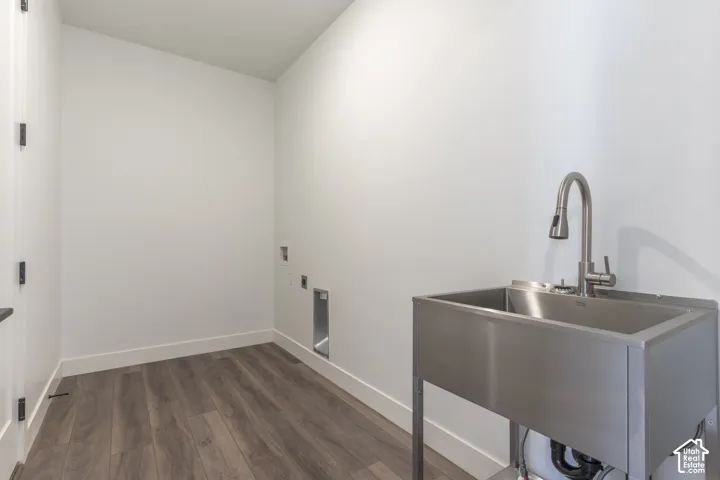 Utility room featuring wood-finish flooring, a freestanding stainless steel utility sink, and a high-arch pulldown faucet