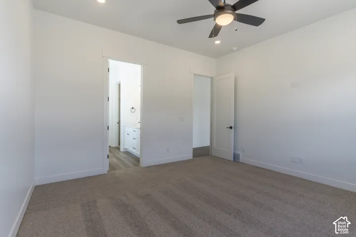 Neutral-toned carpet, ceiling fan with integrated lighting, recessed lighting, and white interior doors with matte black hardware