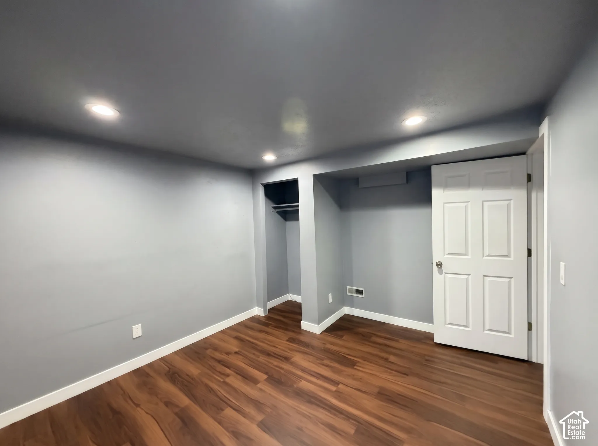 Interior room featuring wood-finish flooring, recessed lighting, and a built-in closet with integrated shelving