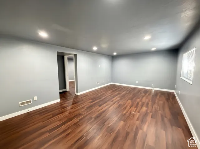 Spacious room featuring wood-finish flooring, recessed lighting, and neutral wall tones