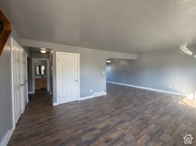 Open interior space featuring wood-finish flooring, neutral wall paint, white six-panel doors, and recessed lighting