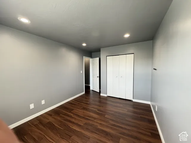 Room featuring wood-finish flooring, recessed lighting, and a multi-panel closet with white doors