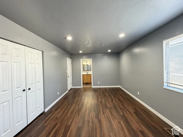Interior room featuring wood-finish flooring, recessed lighting, and a double-door closet with paneled detailing