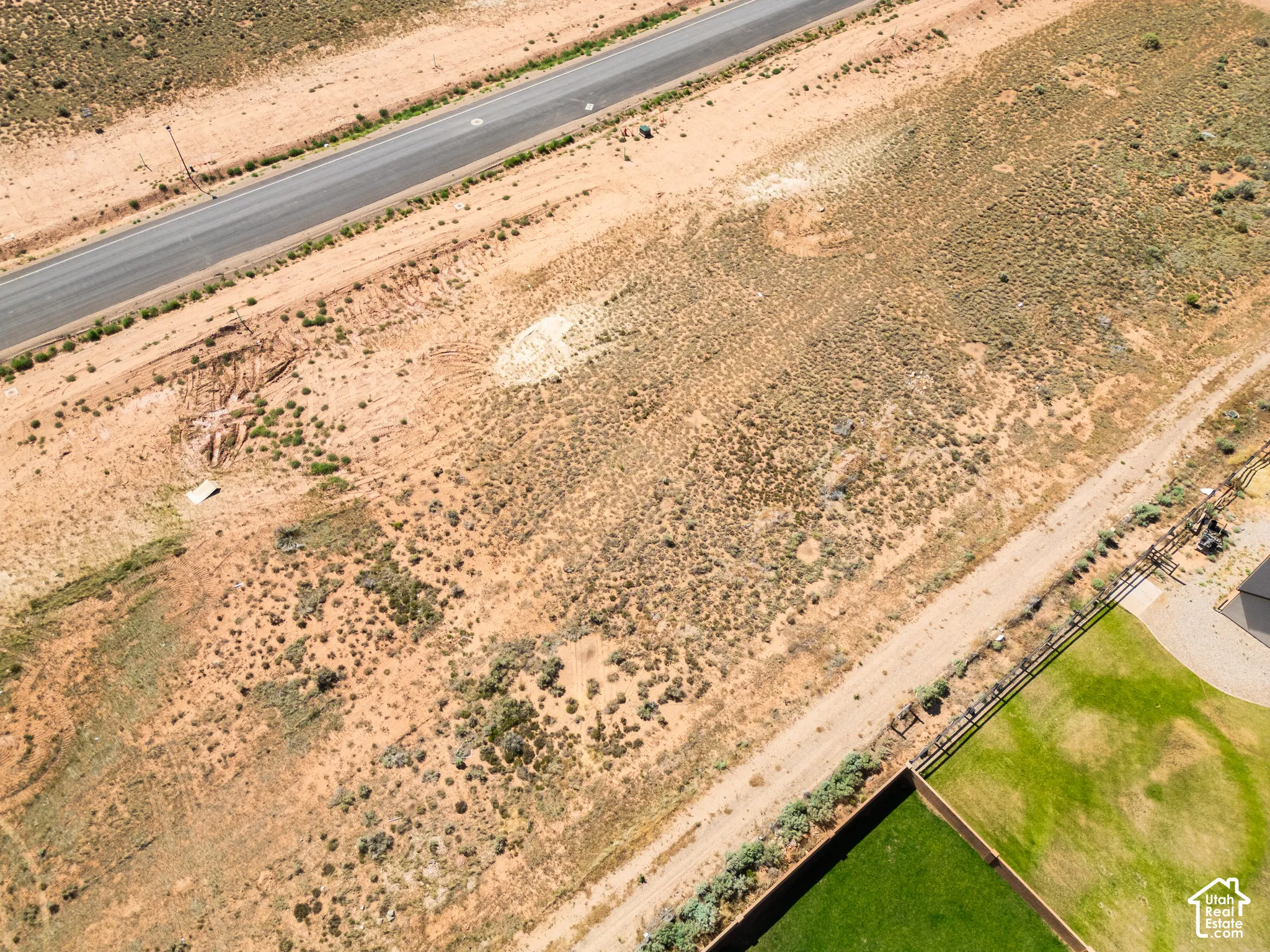 Expansive lot featuring native desert vegetation, an unpaved access path, and established perimeter fencing