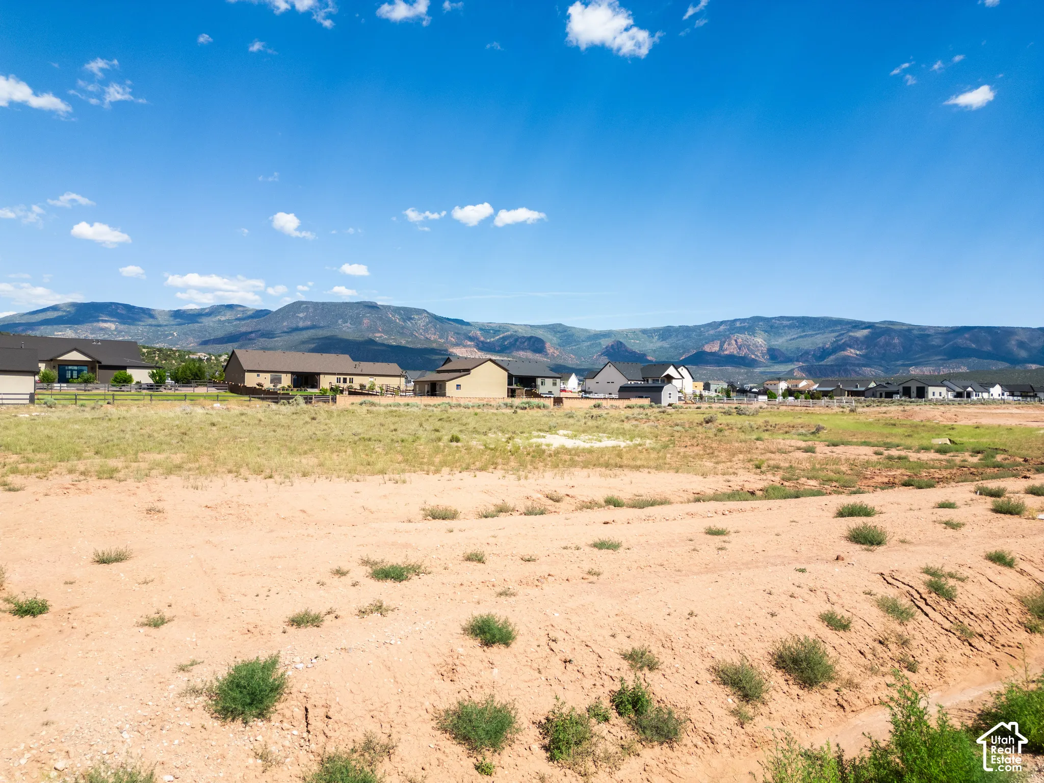 Expansive parcel of land featuring natural terrain and prominent mountain range backdrop