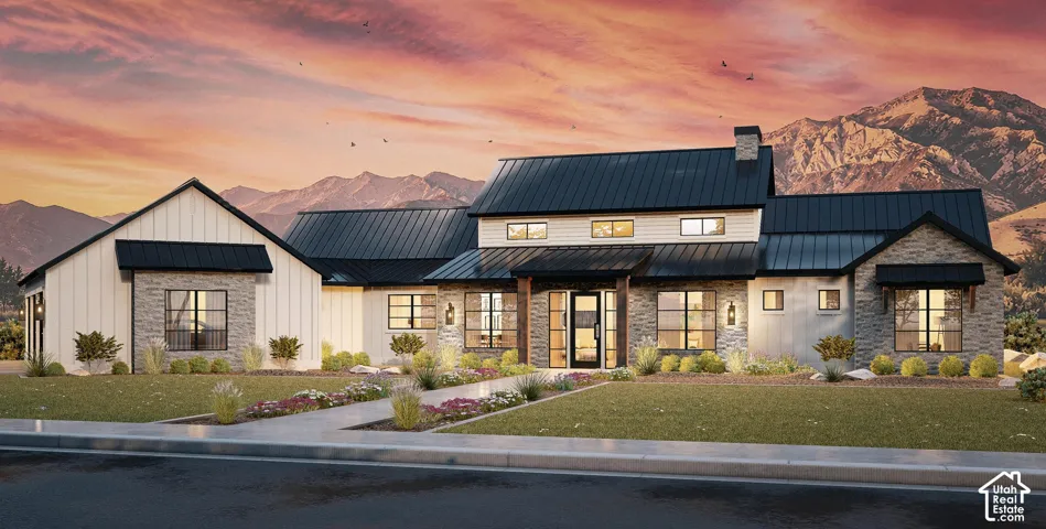 Contemporary exterior featuring vertical board-and-batten siding, stacked stone accents, a dark metal roof, and large-scale mountain backdrop