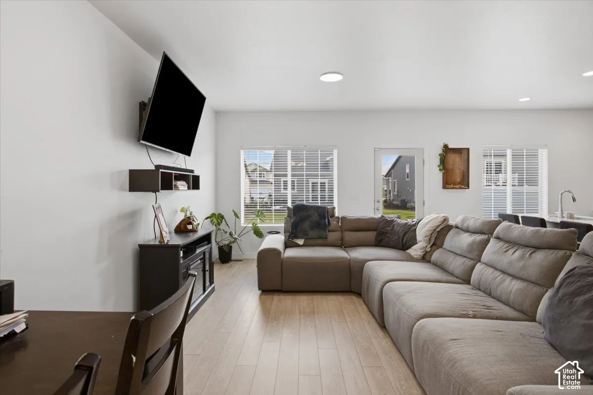 Open-concept interior featuring light wood-finish flooring, recessed lighting, and multiple windows