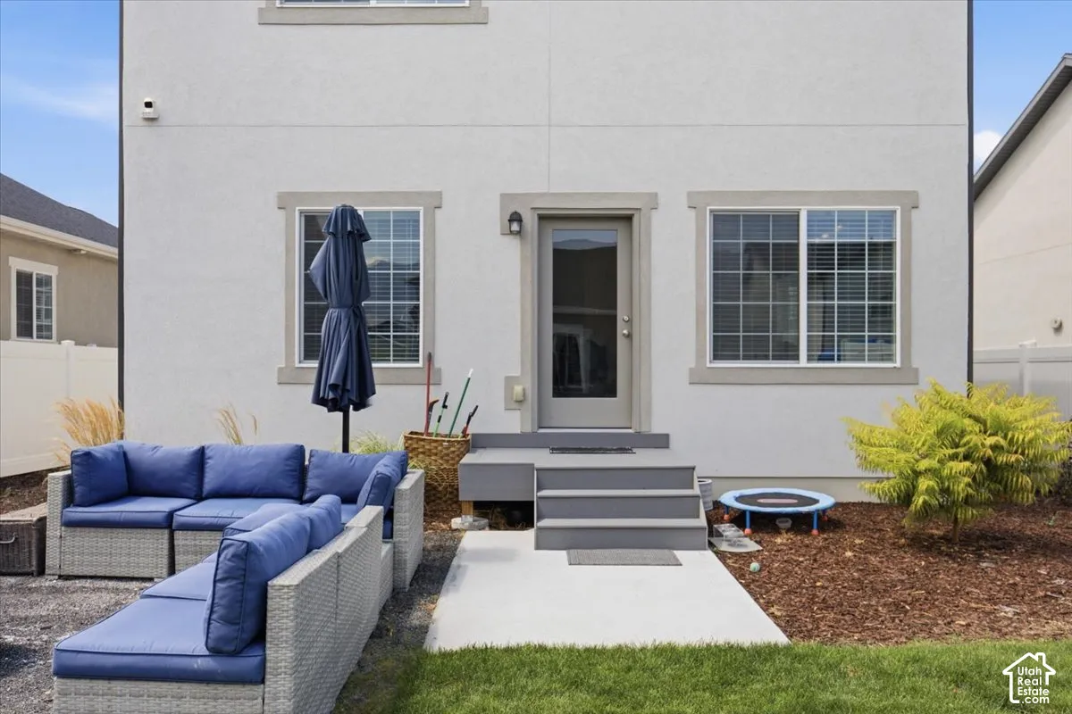 Stucco exterior featuring dual-pane windows, a central glass-panel door, and a painted wood-frame exterior staircase with a concrete landing