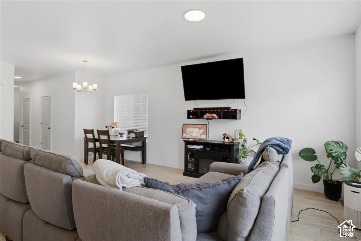 Open-concept interior featuring wood-finish flooring, recessed lighting, and a multi-light chandelier