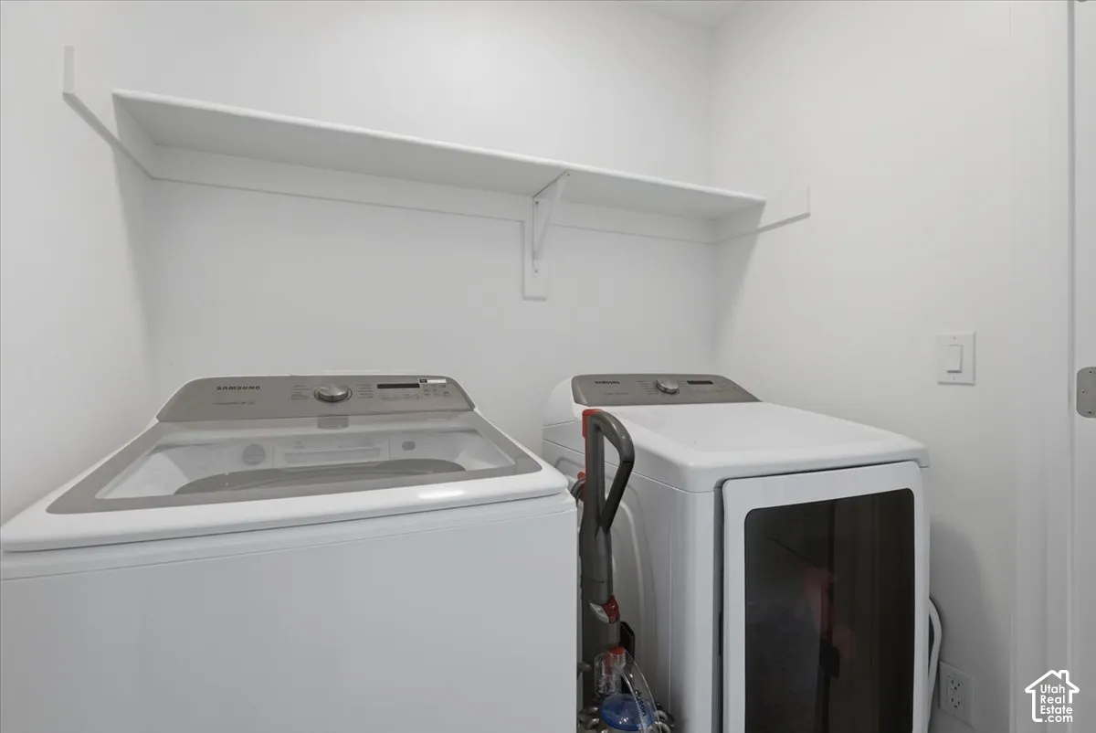 Utility area featuring white walls, neutral paint, and an overhead built-in shelving unit