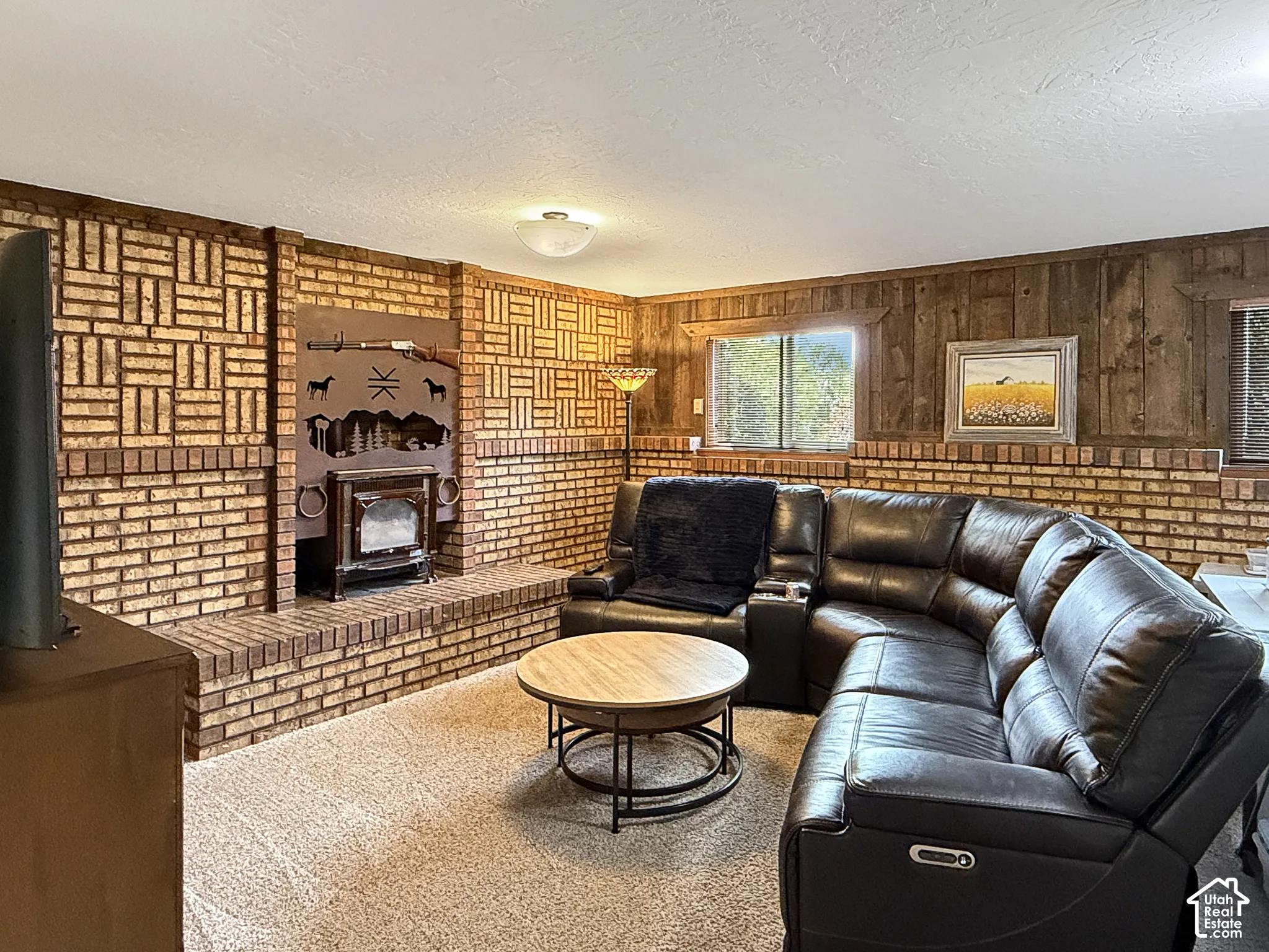 Brick wall cladding with a geometric pattern, wood paneled wall accent, and a built-in brick hearth fireplace
