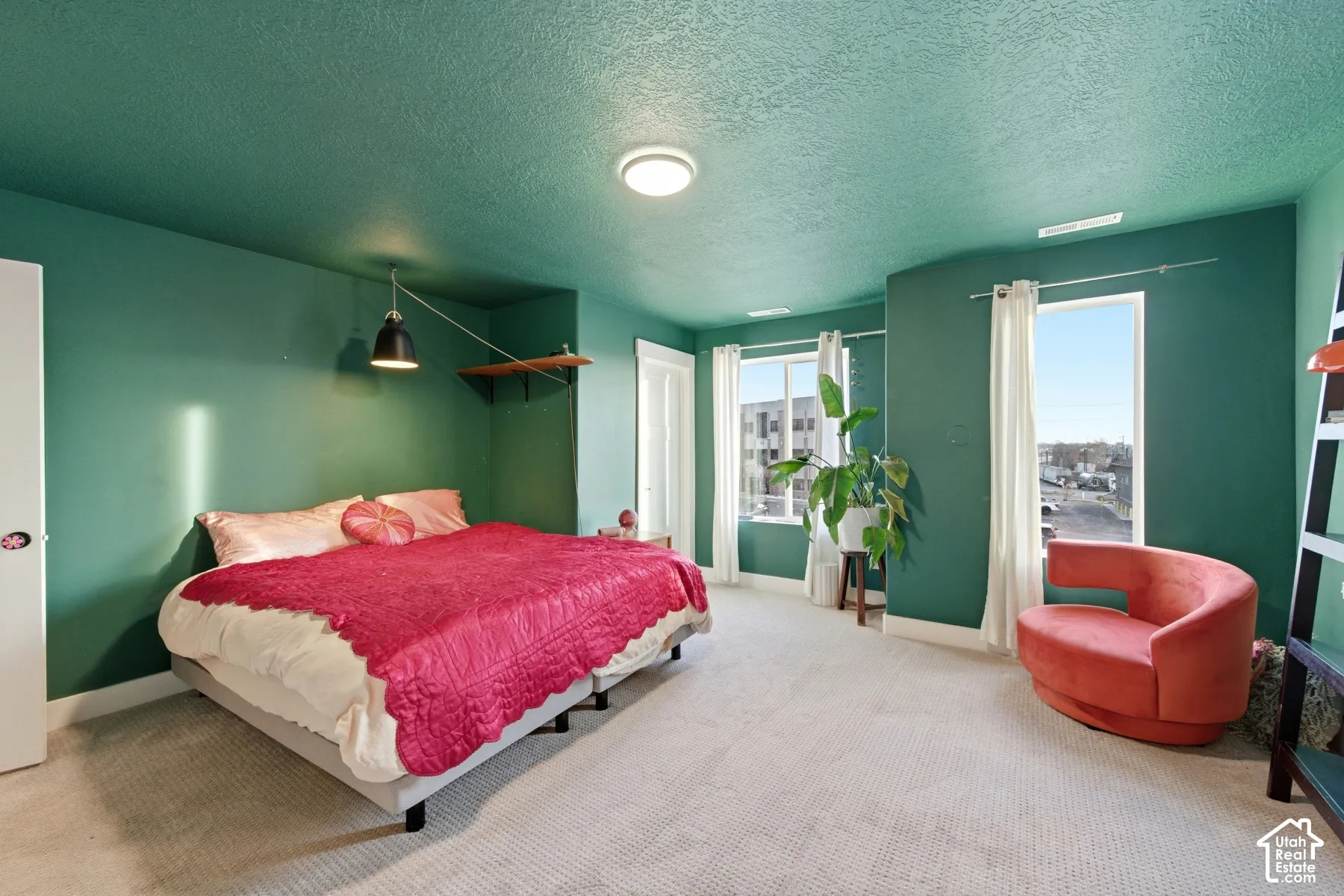 Room featuring wall-to-wall carpeting, dual windows, and a wall-mounted light fixture