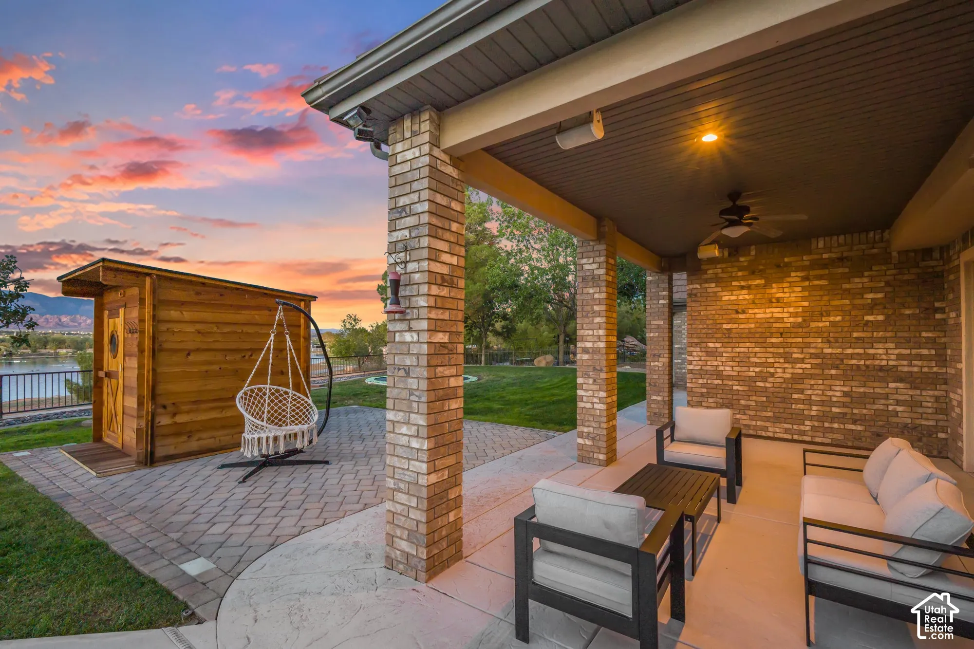 Covered patio with brick columns, brick exterior wall, concrete patio flooring, and detached wooden structure