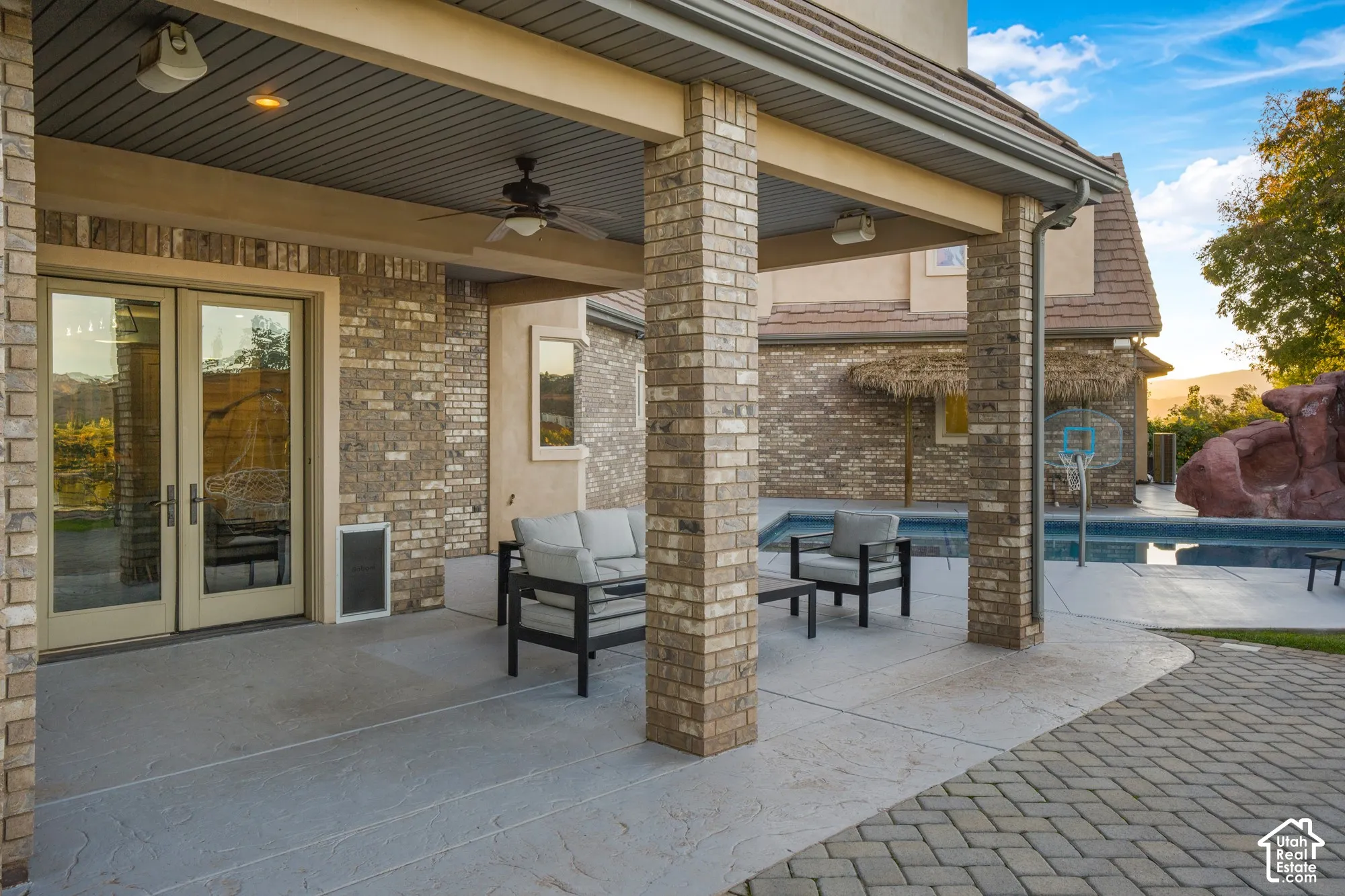 Covered patio featuring brick masonry columns, recessed lighting, ceiling fan, and stamped concrete flooring