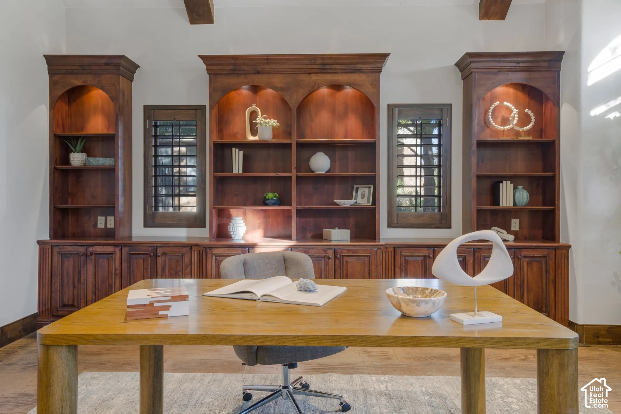 Custom floor-to-ceiling wooden built-in cabinetry featuring arched display shelving, recessed lighting, and wooden-framed windows with security grilles