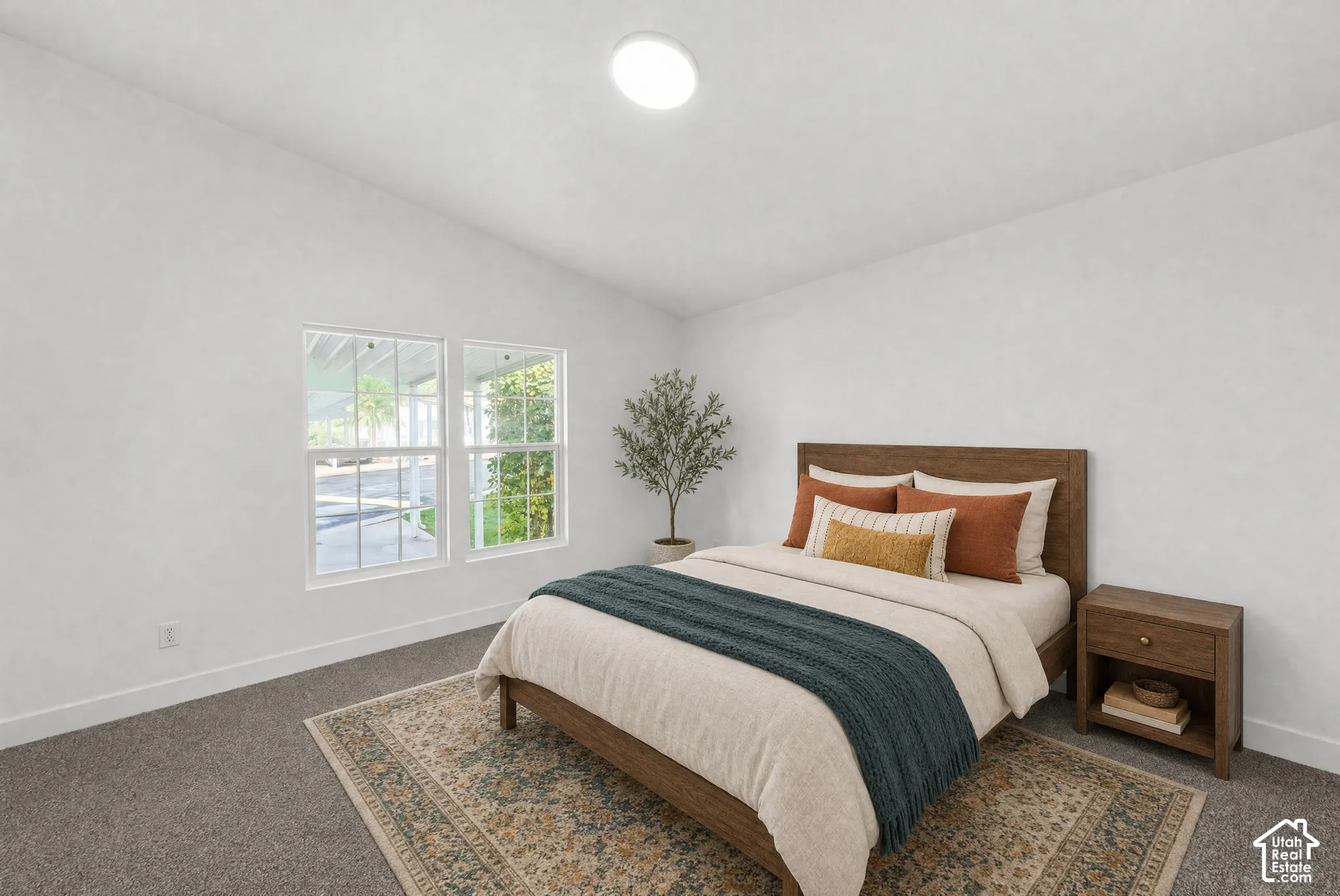 Vaulted ceilings, neutral wall tones, carpeted flooring, and dual-pane windows with grid detailing