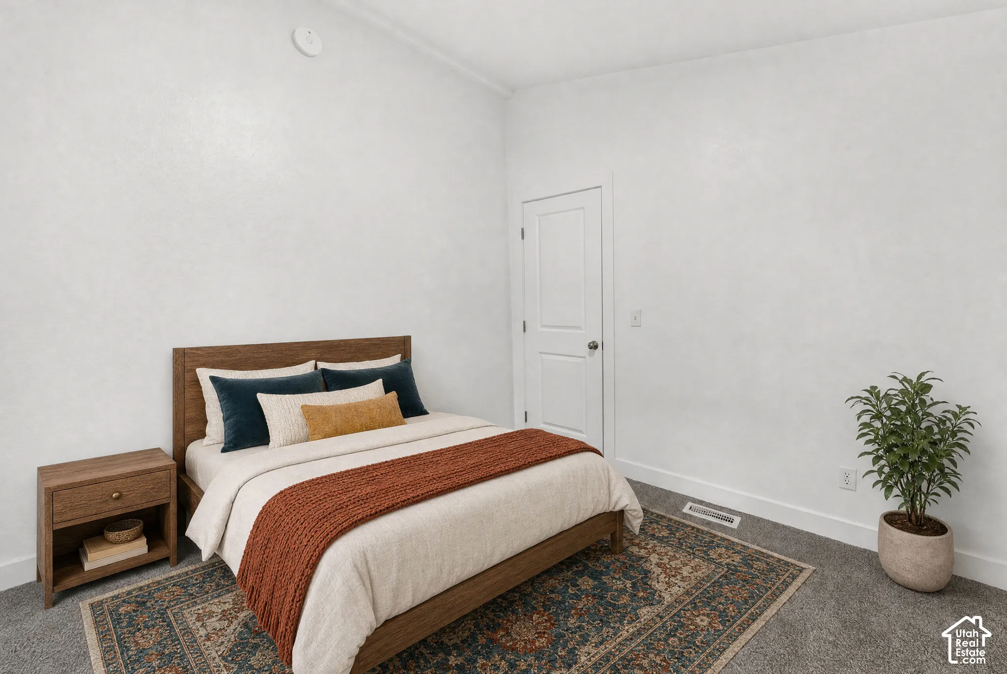 Neutral-toned interior room featuring high ceilings, textured walls, wall-to-wall carpeting, and a two-panel interior door
