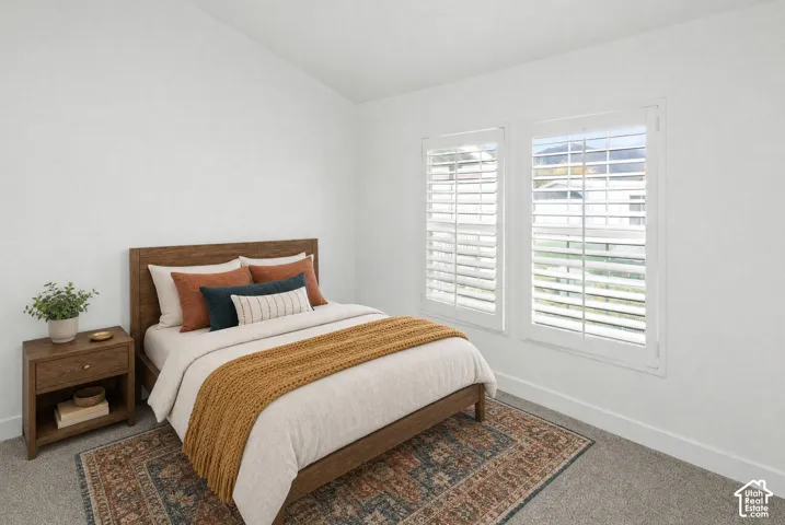 Room featuring crisp white walls, neutral carpeting, and dual windows outfitted with adjustable interior shutters