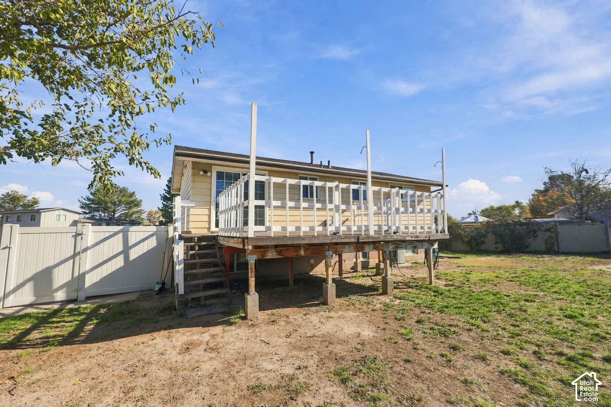 Elevated rear deck with stairs to the backyard and vinyl fencing