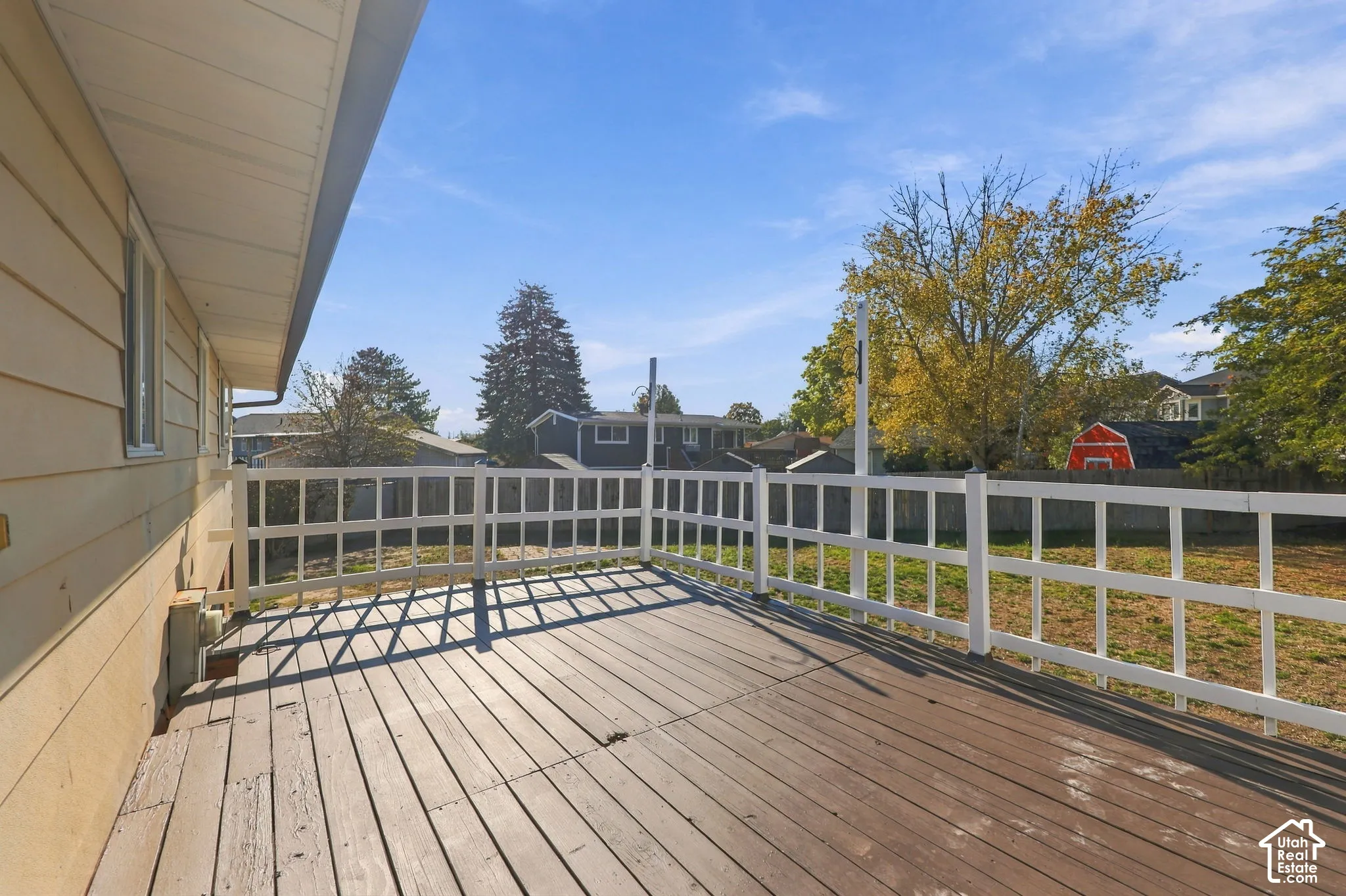 Elevated wood deck with white railing overlooking the backyard