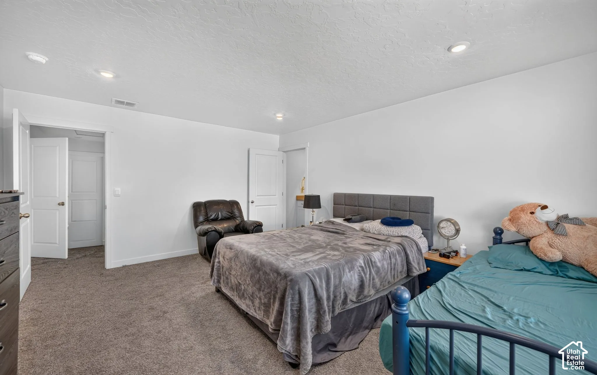 Neutral-toned room featuring plush wall-to-wall carpeting, recessed ceiling lighting, and solid-core interior doors