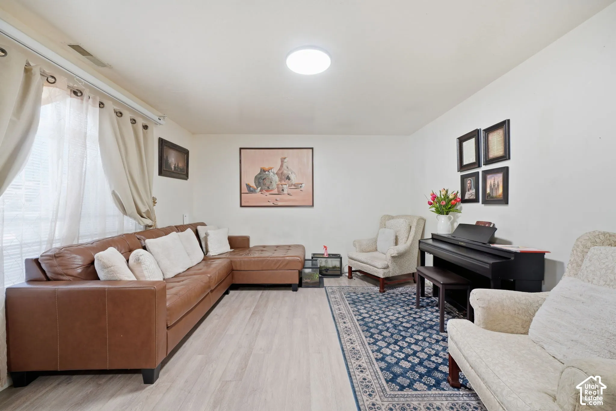 Bright living area featuring wood-finish flooring, neutral wall paint, and a large window