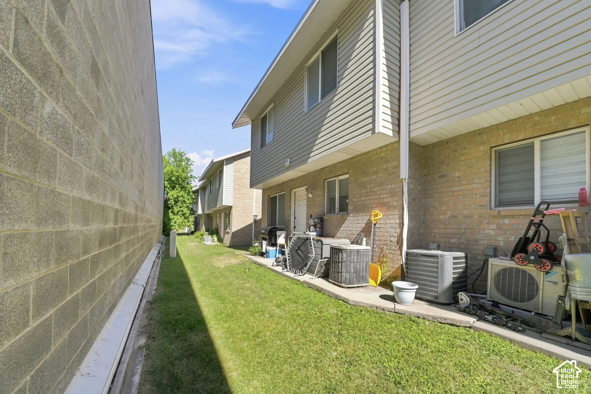 Exterior of multi-unit dwelling featuring horizontal siding, masonry brick lower levels, and concrete ground-level pathways
