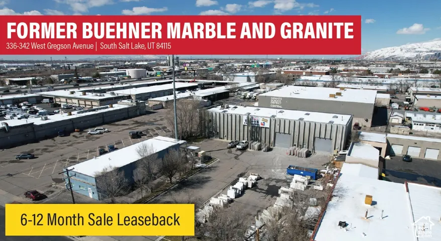 Industrial property complex featuring multiple warehouse structures, concrete-paved parking areas, grade-level loading doors, and fenced exterior storage space