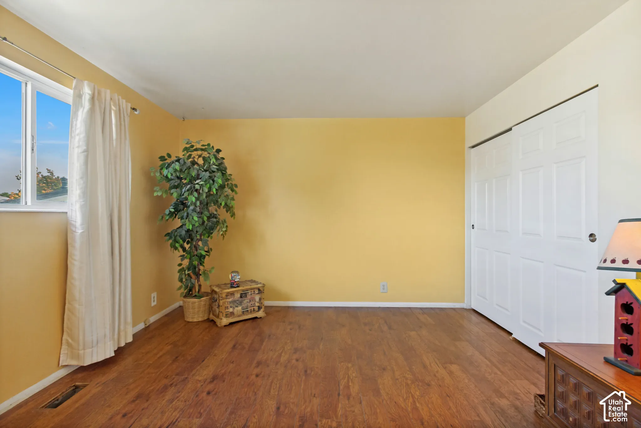 Interior space featuring wood-finish flooring, a sliding bypass closet with paneled doors, and a window with natural light