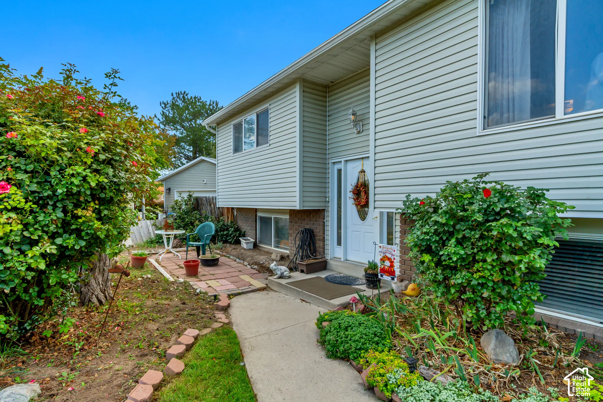 Vinyl siding exterior, concrete walkway, and brick-accented entryway