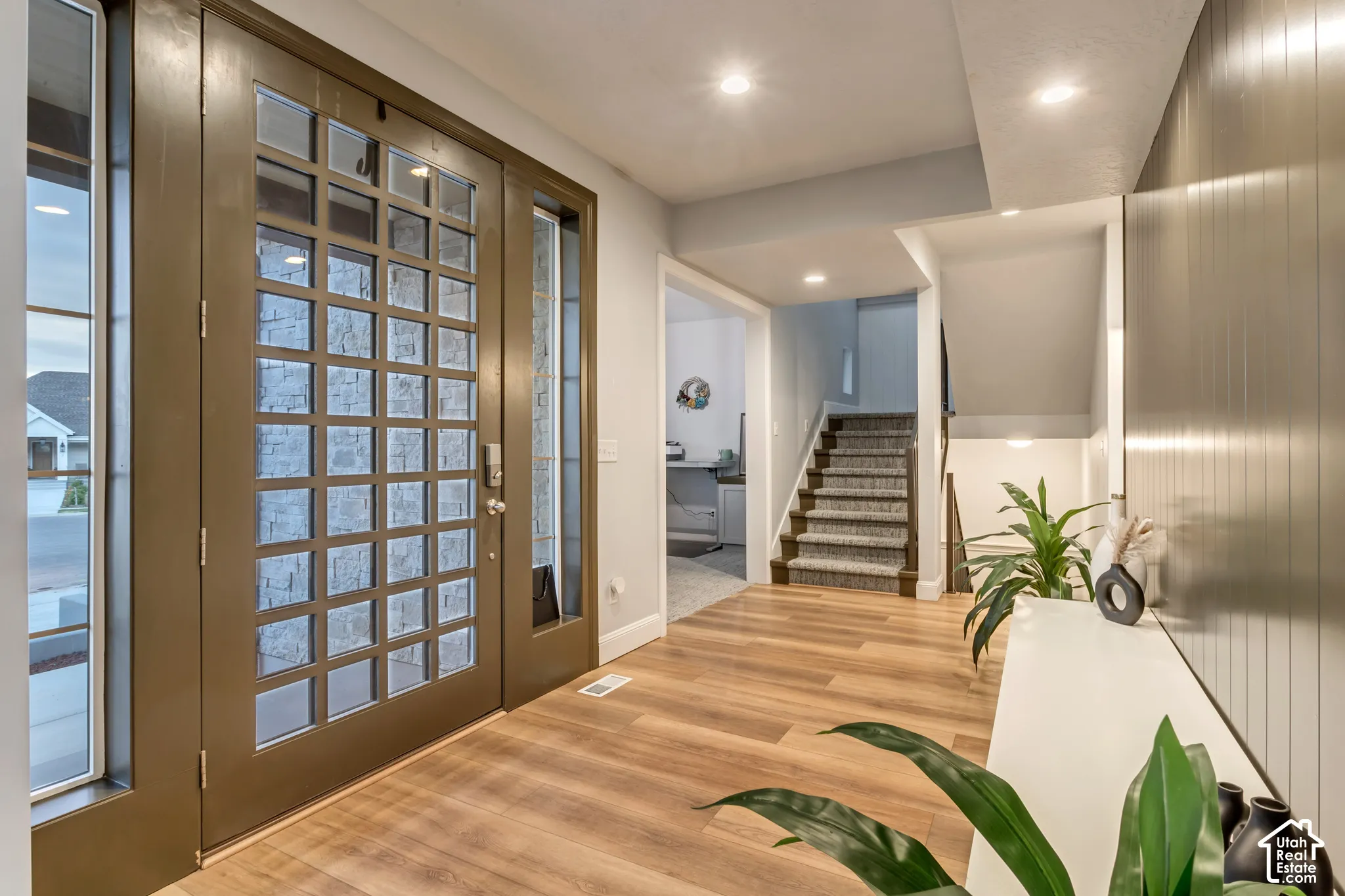 Entryway featuring a multi-pane glass door, wood-finish flooring, recessed lighting, and a vertical paneled accent wall