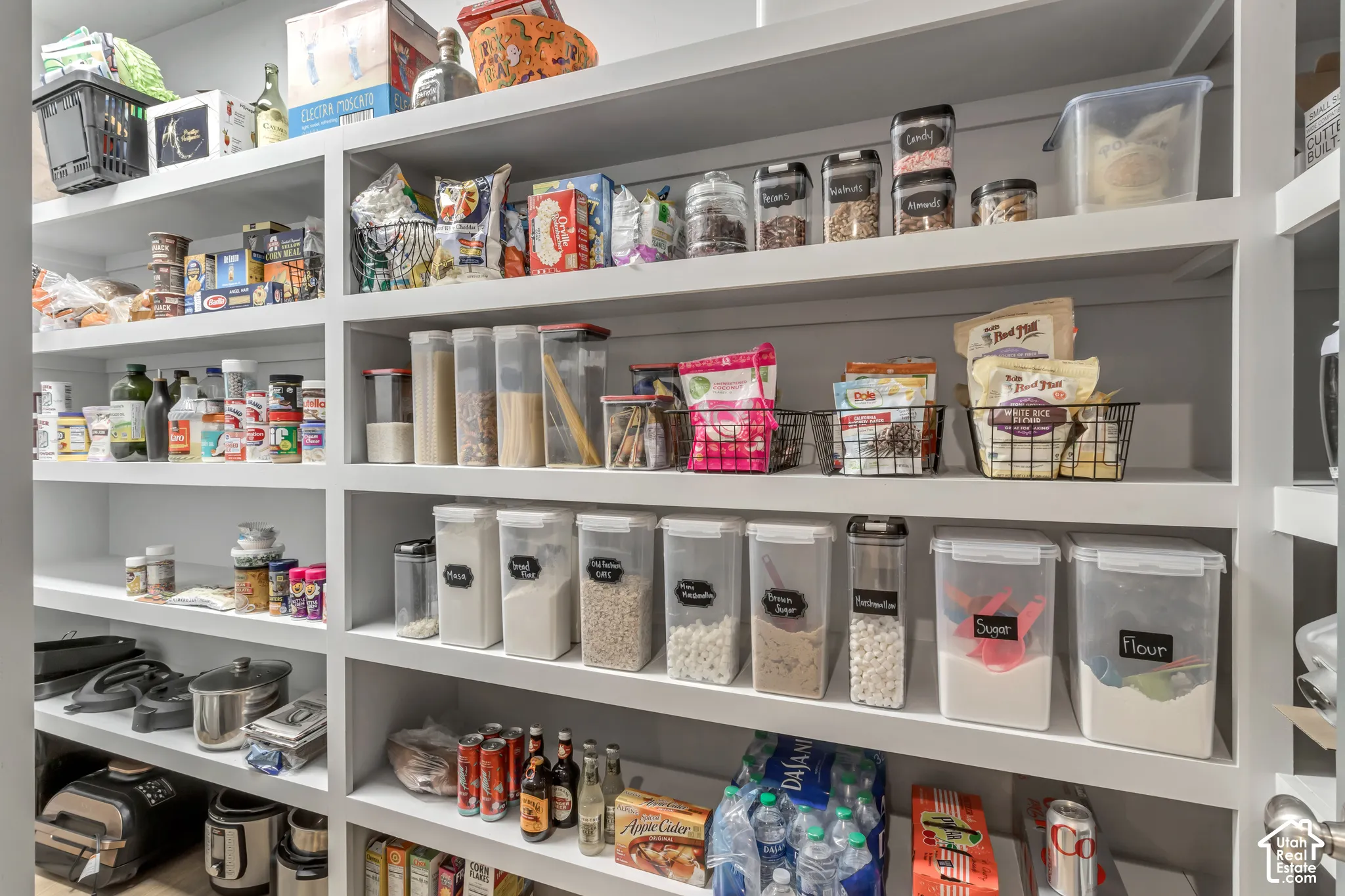 Walk-in pantry featuring custom built-in white shelving with multiple levels of storage