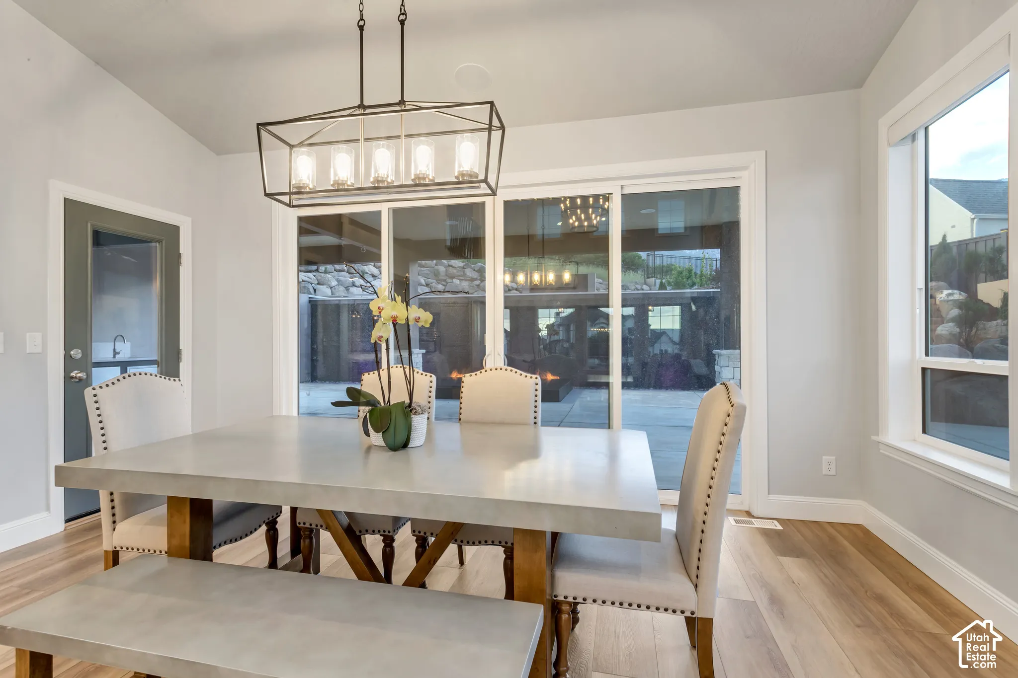 Wood-finish flooring, vaulted ceilings, and a geometric-frame pendant light fixture