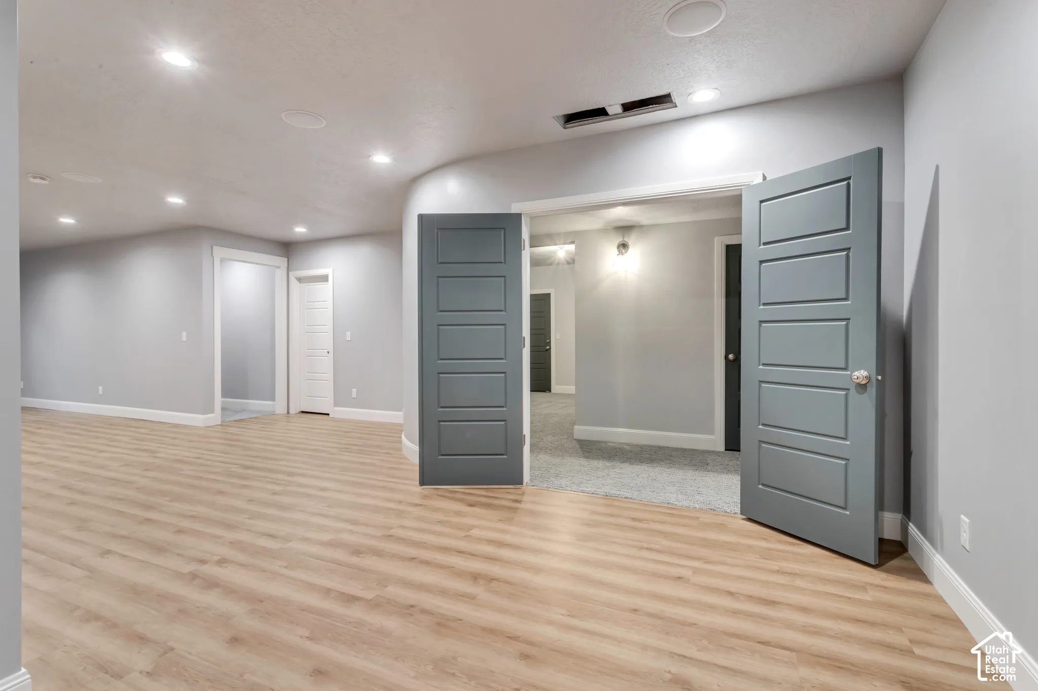 Interior space featuring light wood-finish flooring, recessed lighting, and five-panel interior doors with a matte finish