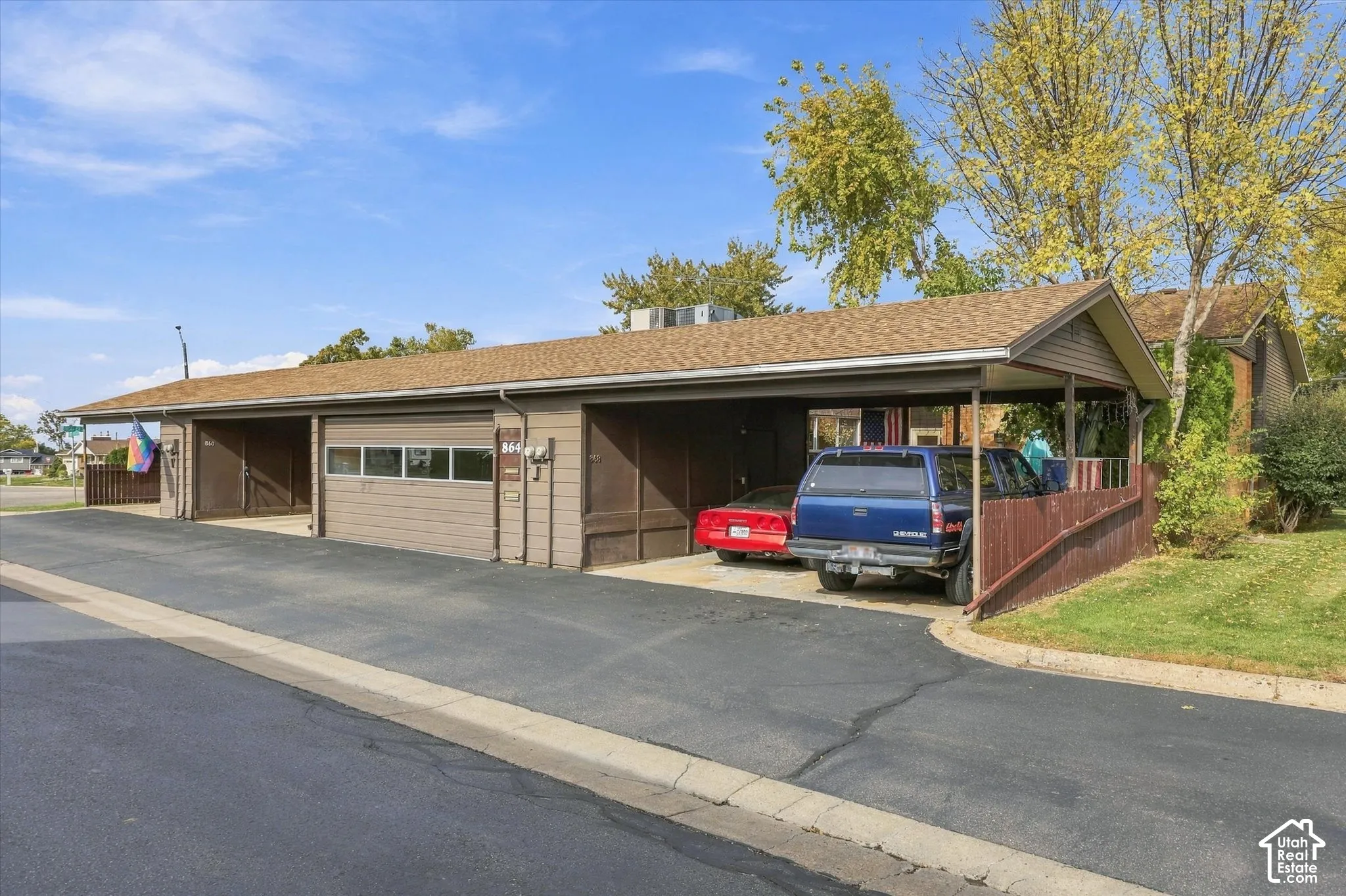 Multi-bay carport featuring a brown-toned exterior, shingle roofing, and asphalt-paved driveway