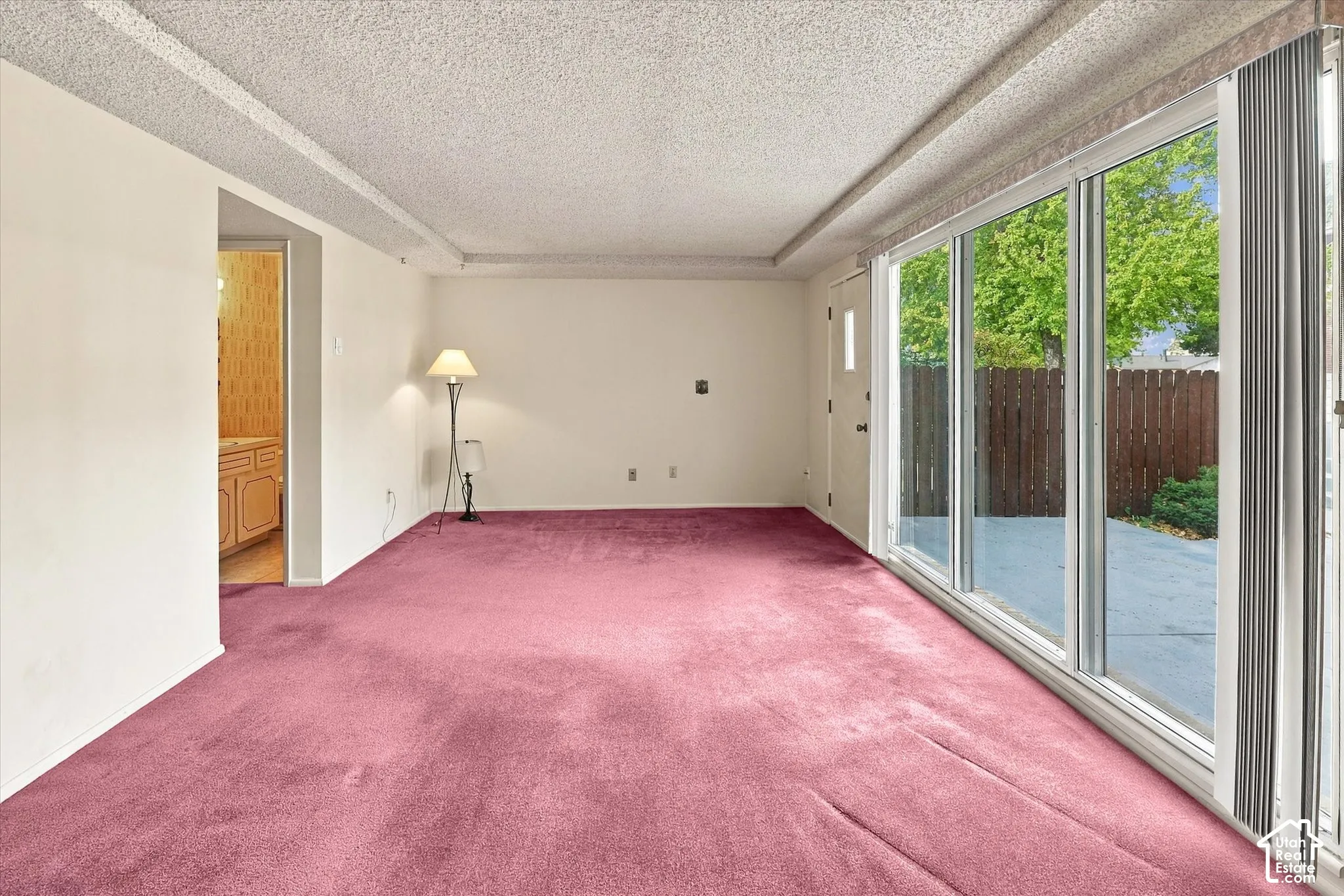Interior space featuring wall-to-wall carpeting and a ceiling with a textured finish