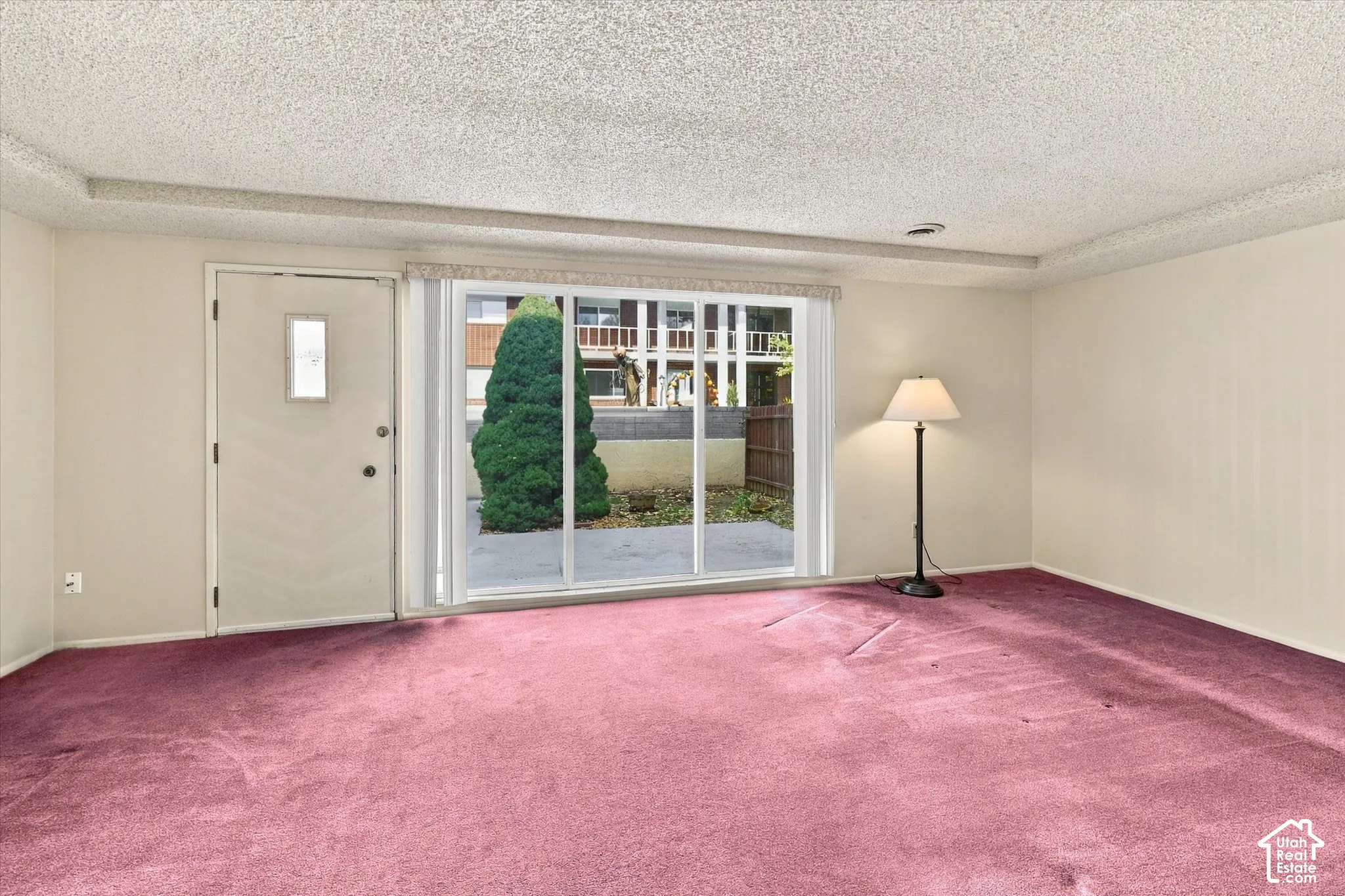 Interior space featuring wall-to-wall carpeting, a sliding glass door, and a single-panel entry door