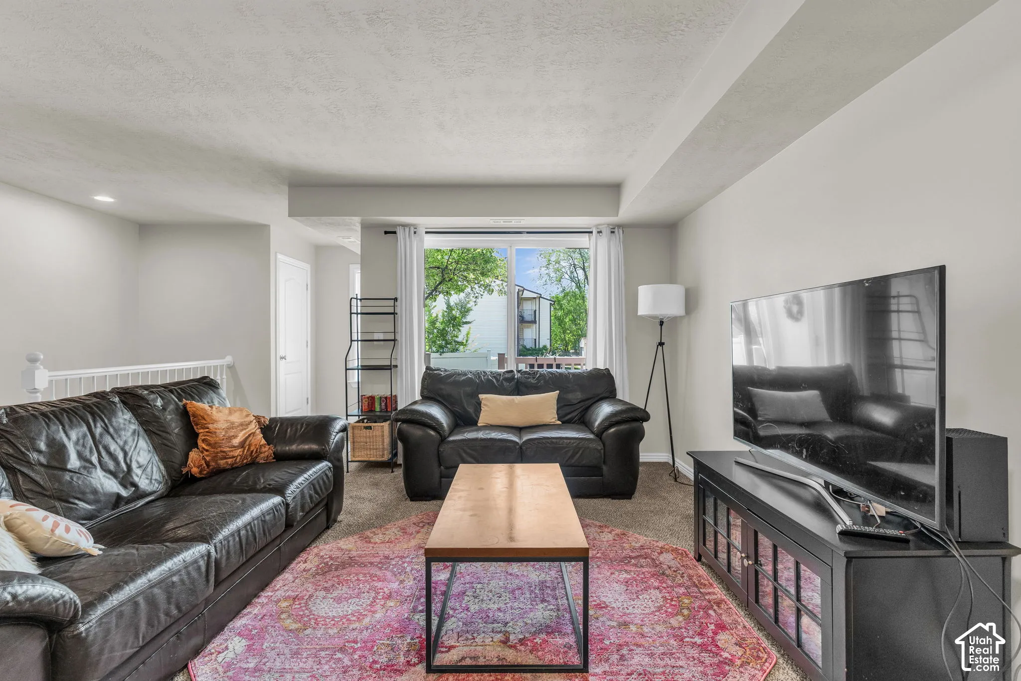 Living space featuring neutral wall paint, carpeting, recessed lighting, and a large window