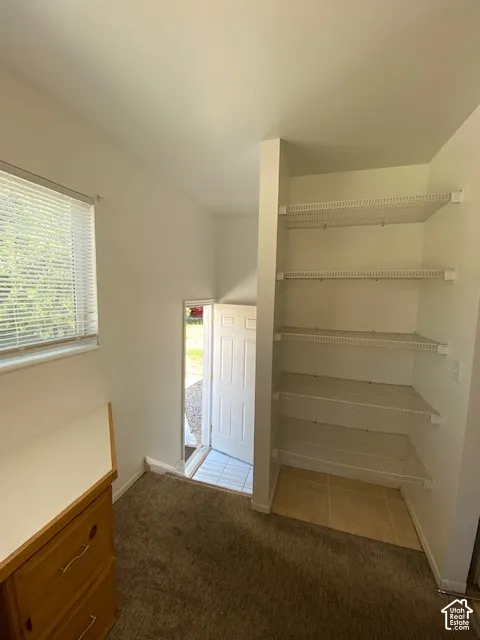 Built-in cabinetry featuring a workspace surface, multi-tier wire shelving, and a horizontal window with blinds