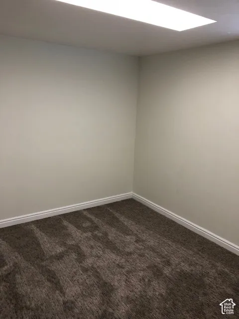 Interior space featuring neutral wall tones, textured carpeting, and a flush-mount rectangular light fixture