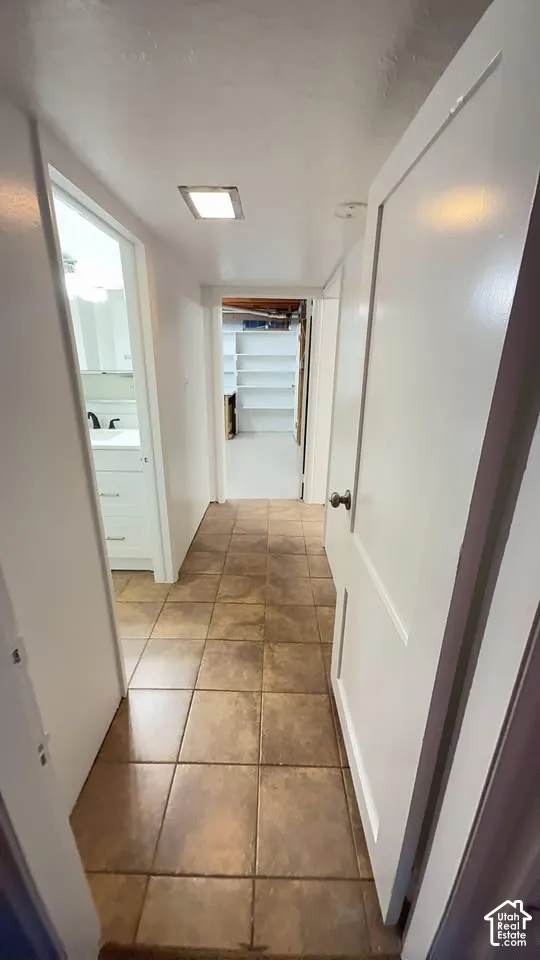 Hallway featuring tiled flooring, recessed ceiling lighting, and built-in shelving