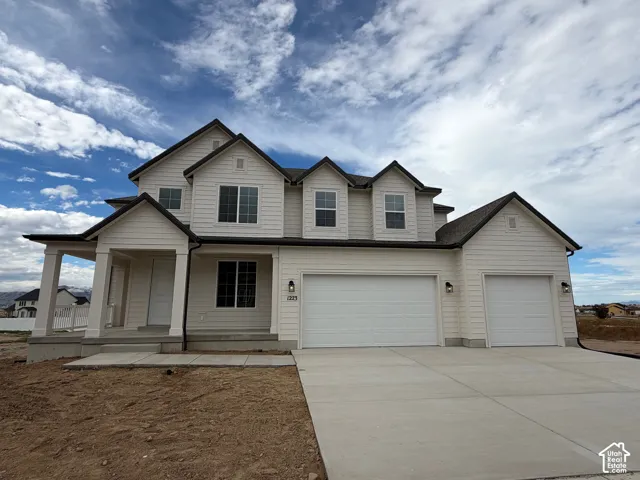 Two-story exterior featuring horizontal siding, a gabled roofline, three dormer windows, a covered front porch, and a three-car garage
